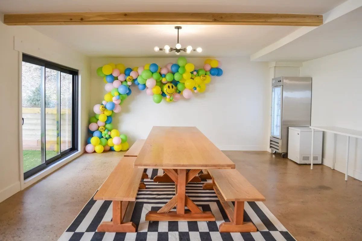 The lunch room at Happy Day — long communal table set for kids with snacks and water cups, a chalkboard menu on the wall.
