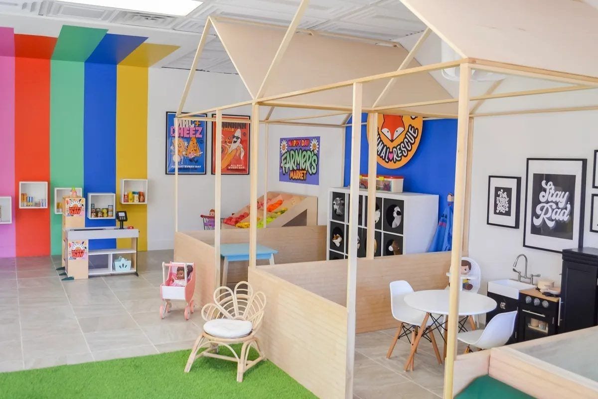 A "Stay Rad" mural on the back wall at Happy Day — bright lettering above a corner full of kid art and craft supplies.