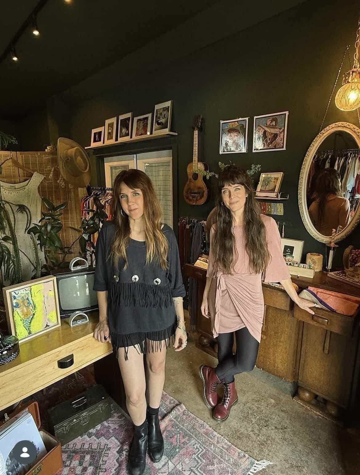 The owners of Highway Queen standing inside the shop — vintage finds, hand-curated apparel, and a warm, lived-in studio behind them.