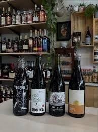 The featured-bottle showcase near the front door at Piney Wine & Spirits — a curated selection of new releases on a small wooden display.