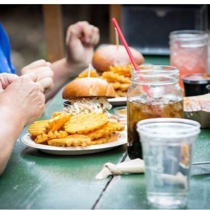 Two burgers and a heaping side of waffle fries on a wooden tray at Switchback Smokehouse.